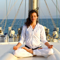yoga instructor on ship top deck in a pose