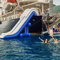 guests swimming next to ship with water slide and open apparel