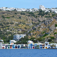 coastal island town with white houses and rocky hills