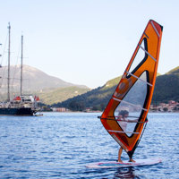 windsurfing next to ship next to island