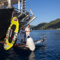 crew member on ship's apparel with watersports equipment near island