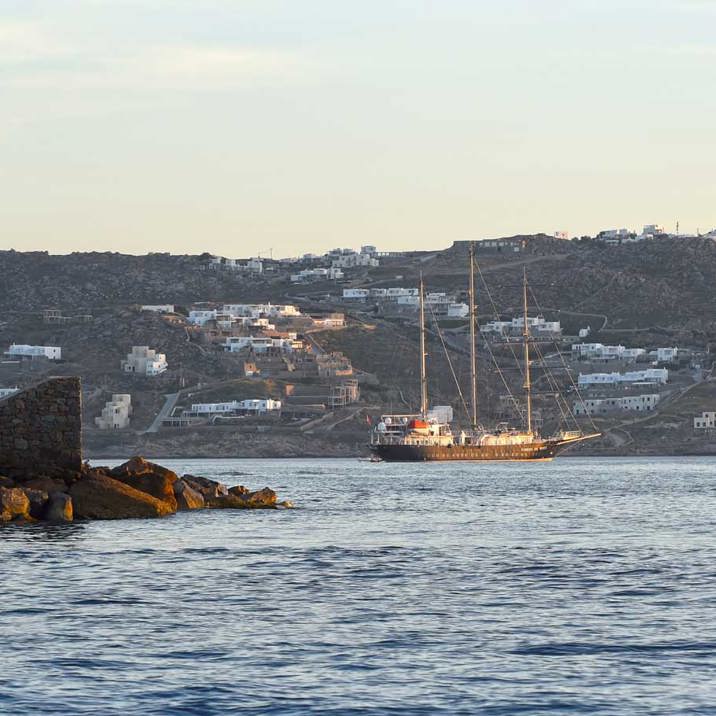 ship next to coast town and lighthouse