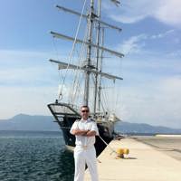 captain in front of the ship in harbor