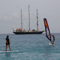 guests windsurfing near ship
