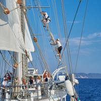 guest climbing mast above crew member